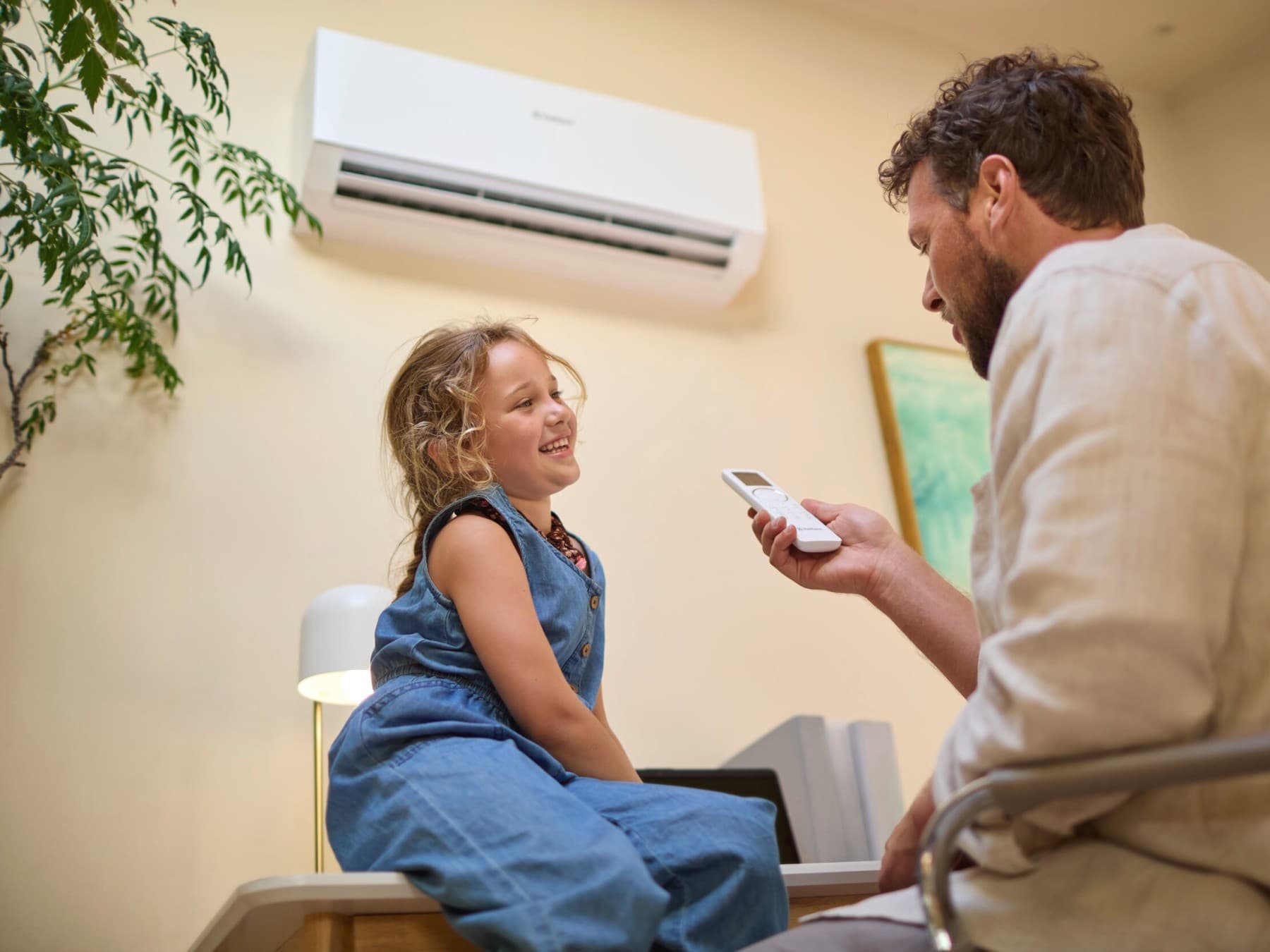 Ojciec i dziecko siedzący pod klimatyzacją