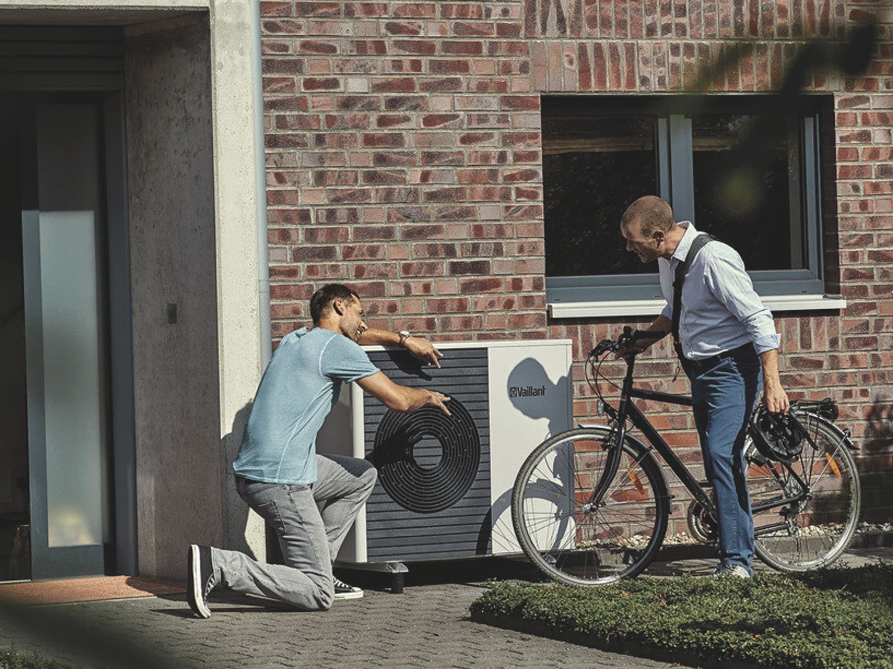Vaillant_Mężczyzna montuje pompę ciepła. Zużycie prądu w domu inwestora nie będzie wysokie dzięki wyborowi nowoczesnego urządzenia grzewczego.