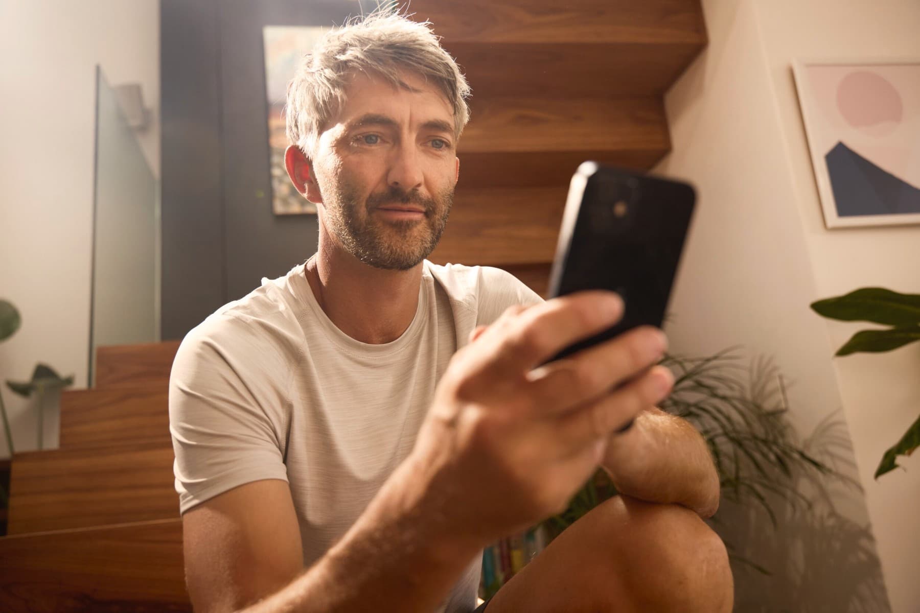 mężczyzna ustawia ogrzewanie za pomocą telefonu.