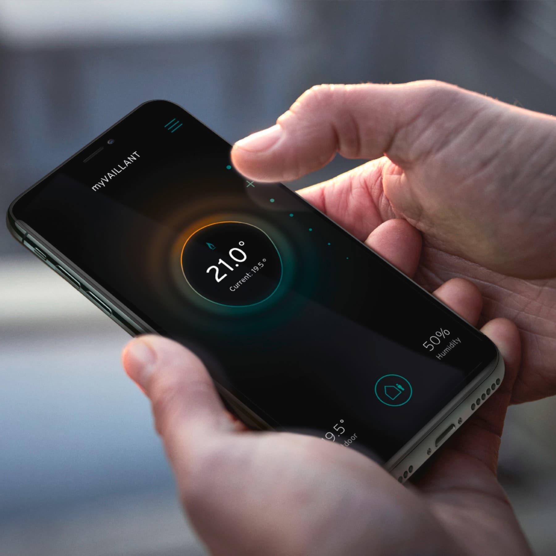 Ręka trzymająca smartfon z aplikacją do sterowania domem.