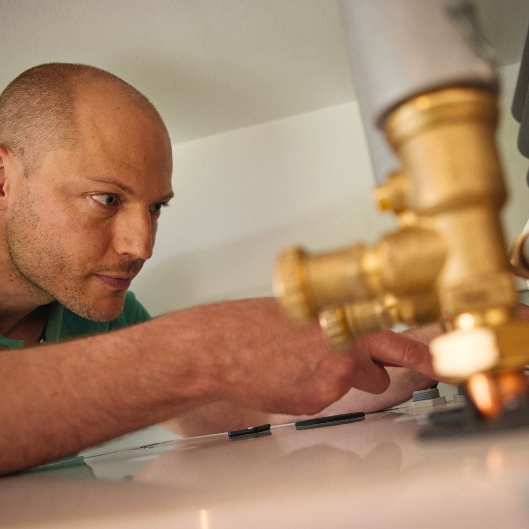 Instalator podłączający budynek do elementów infrastruktury ciepłowniczej.