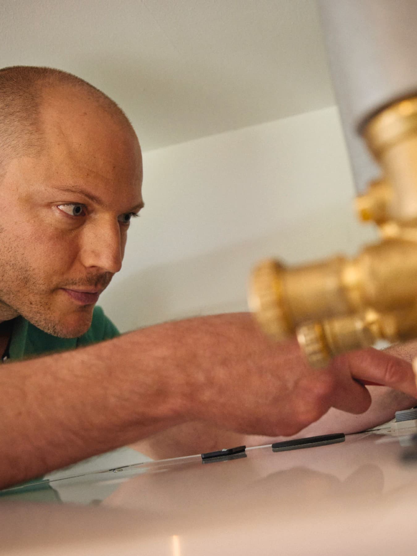 Instalator podłączający budynek do elementów infrastruktury ciepłowniczej.